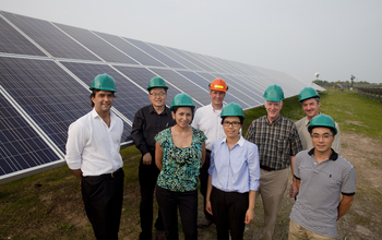 group of people next to solar panels